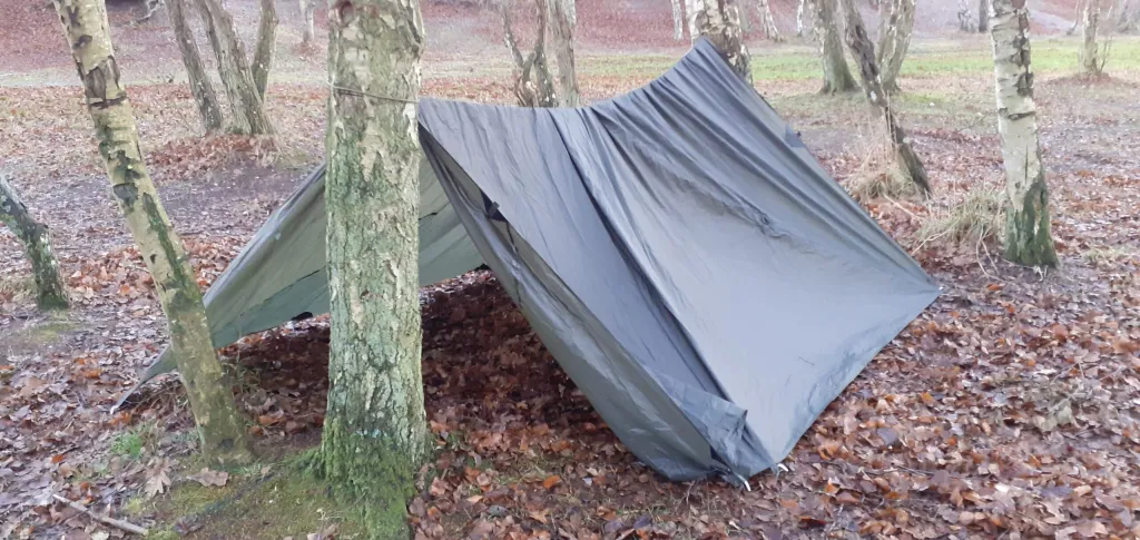Snugpak All Weather Shelter G2 sat op i A-form mellem to træer i skoven